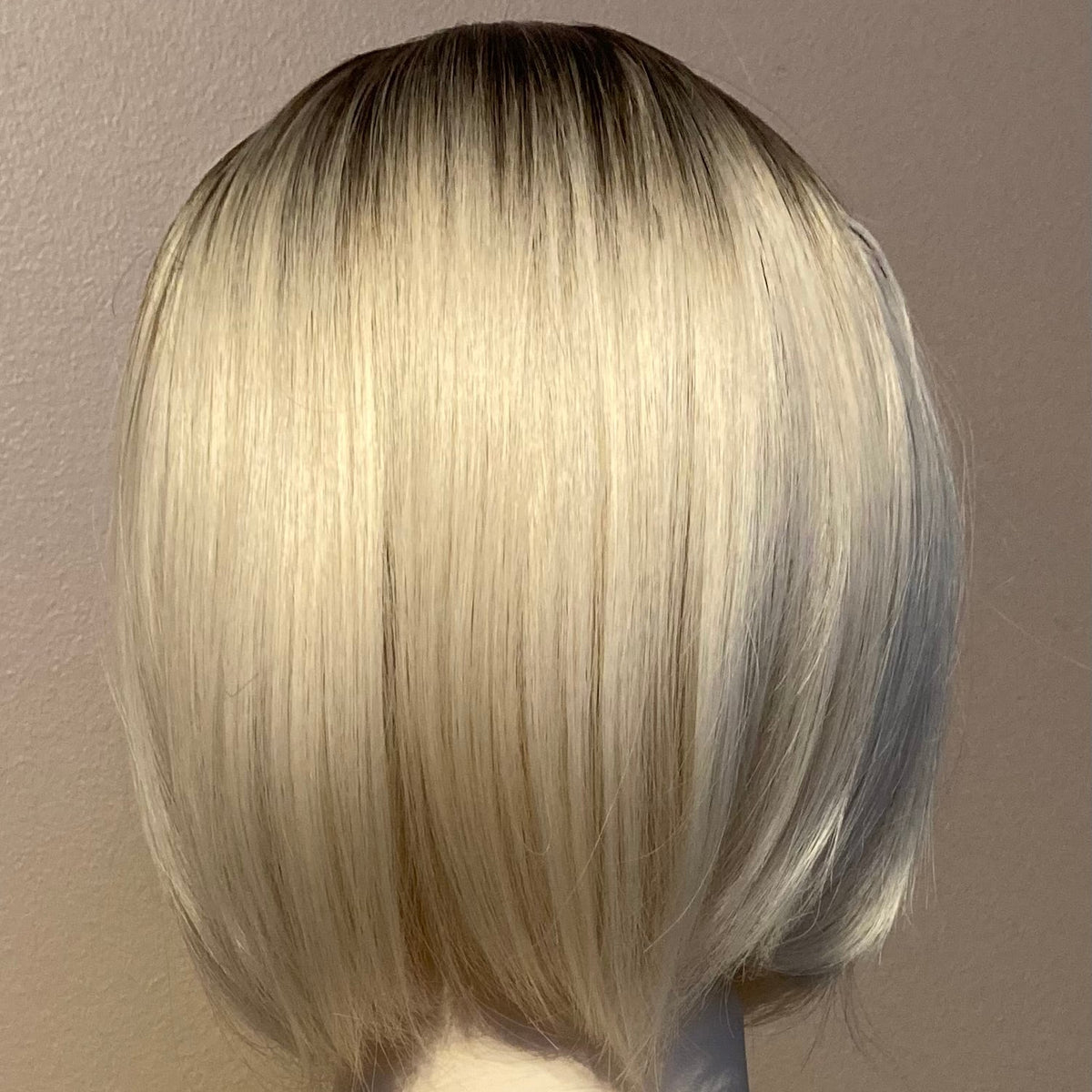 Elegant blond bob-parykk med pannelugg og mørk ettervekst