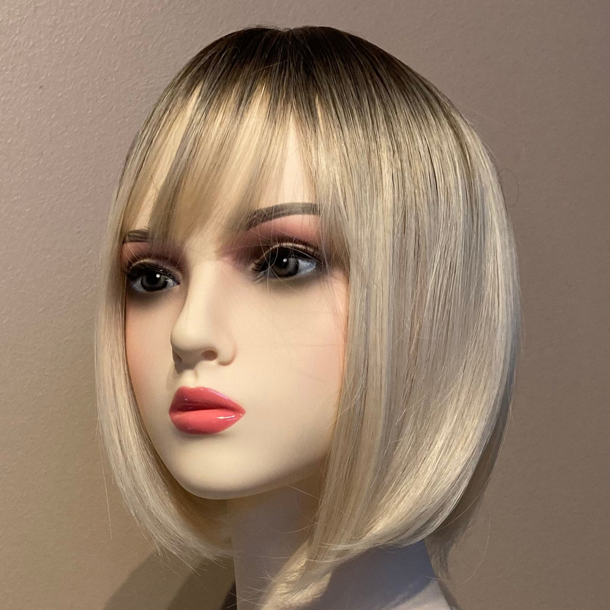 Elegant blond bob-parykk med pannelugg og mørk ettervekst