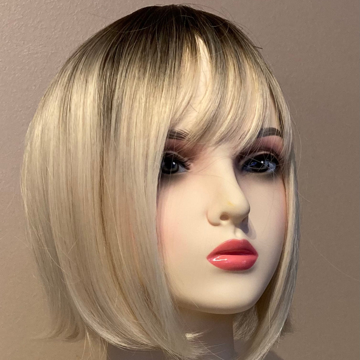 Elegant blond bob-parykk med pannelugg og mørk ettervekst